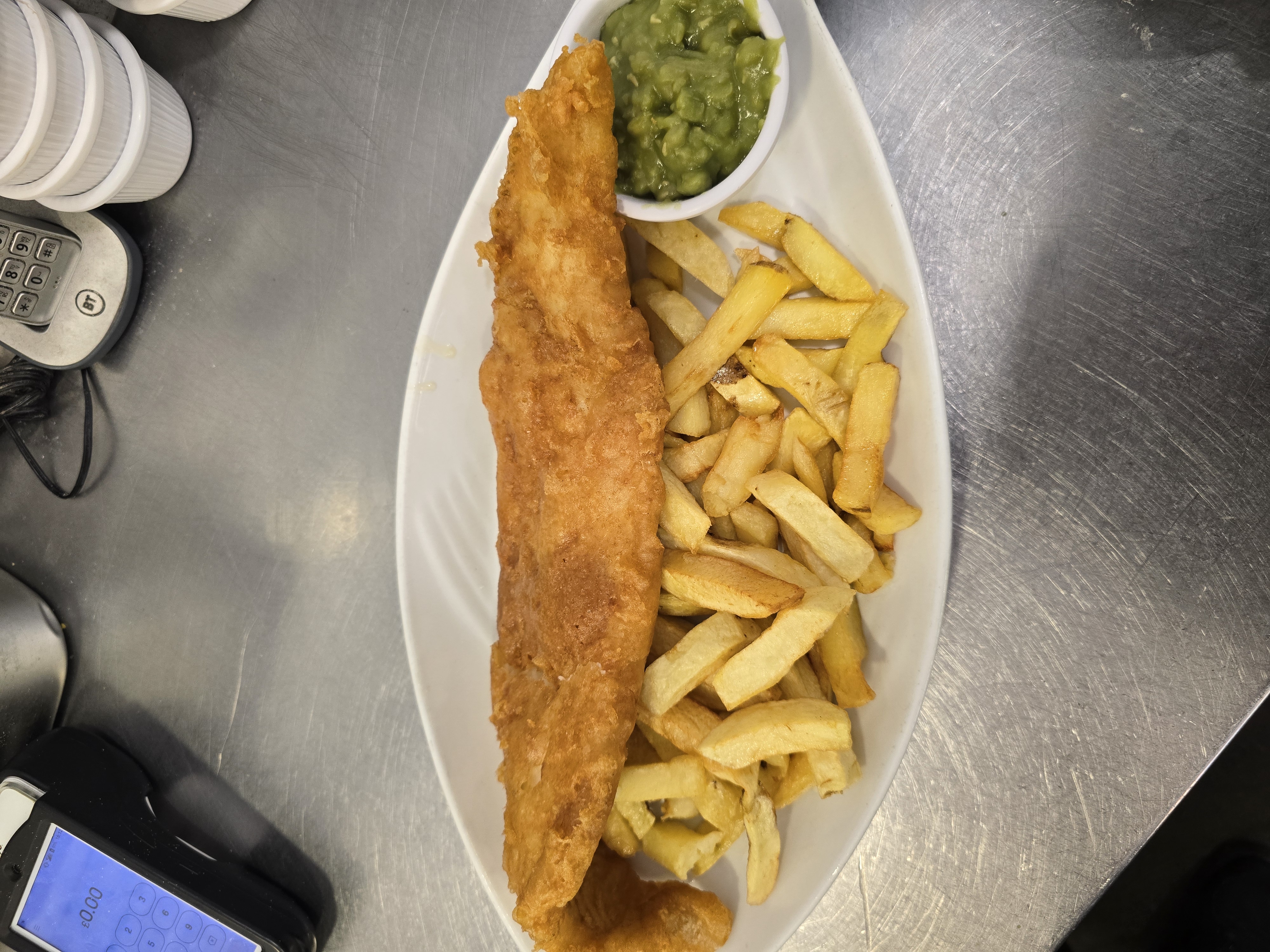 A plate of sumptuous Fish & Chips with a side of Mushy Peas