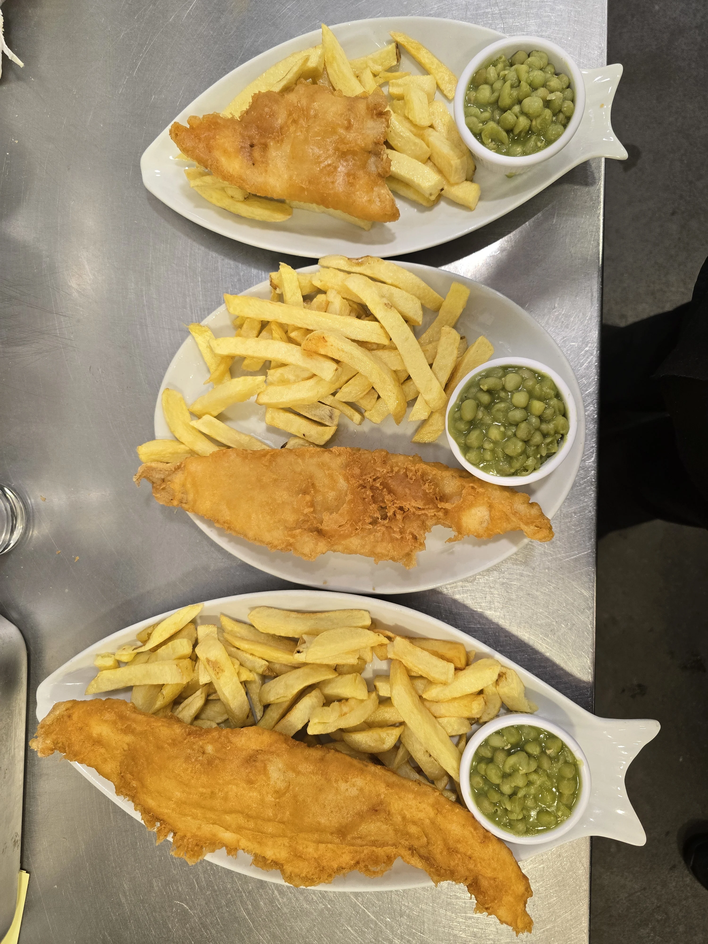 A plate of sumptuous Fish & Chips with a side of Mushy Peas